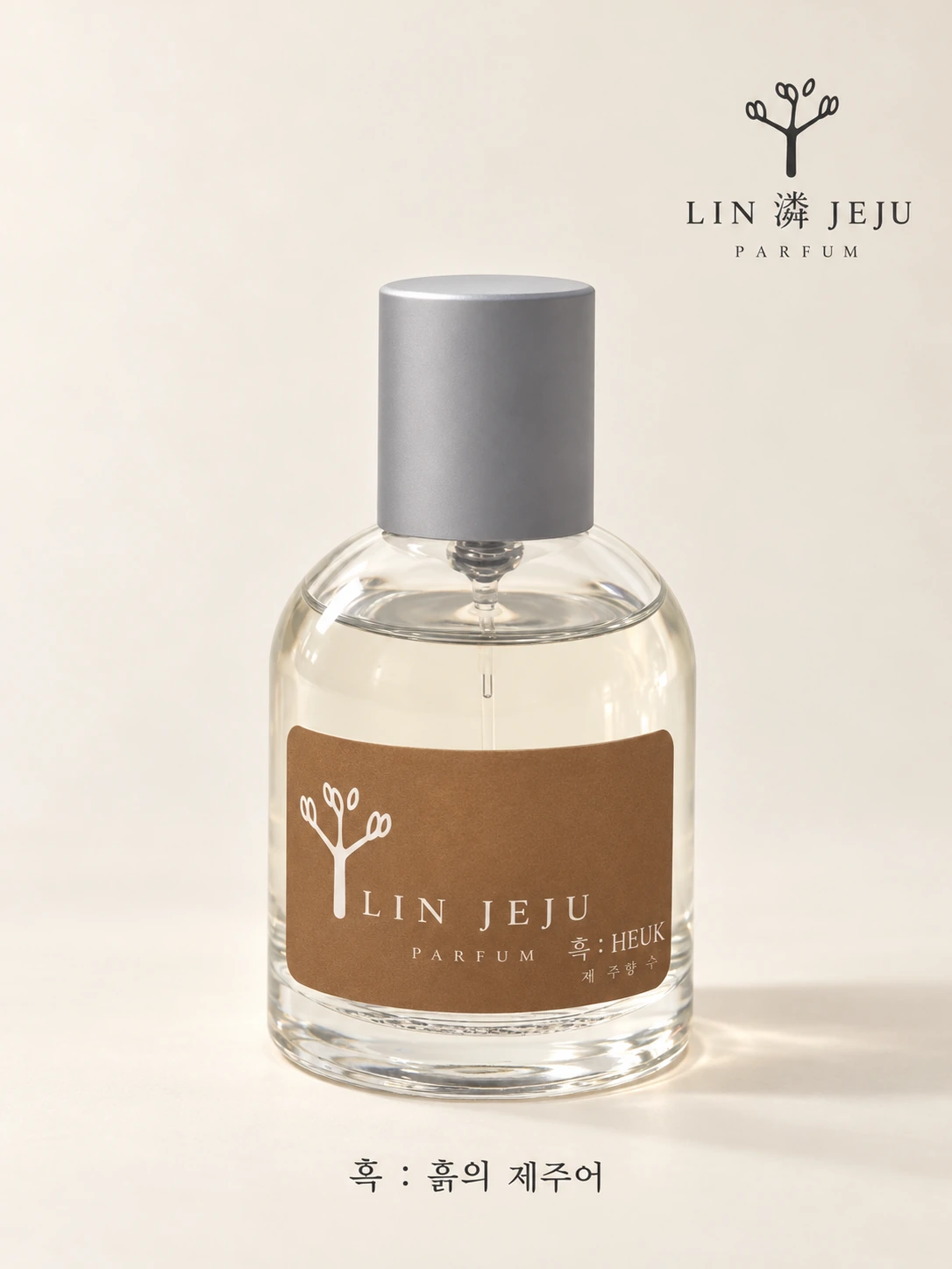 흑 HEUK 파퓸. 회색 캡과 흙빛 라벨의 투명한 유리 보틀, 브랜드 제공 제품 이미지.